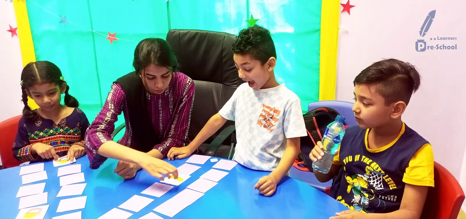 A teacher leading a group memory game with four students