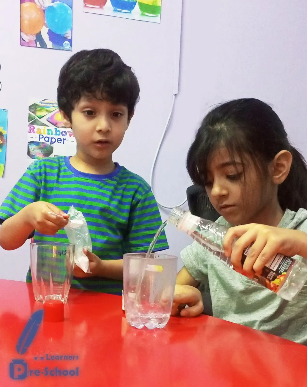 Two students pouring and mixing liquids in a science experiment