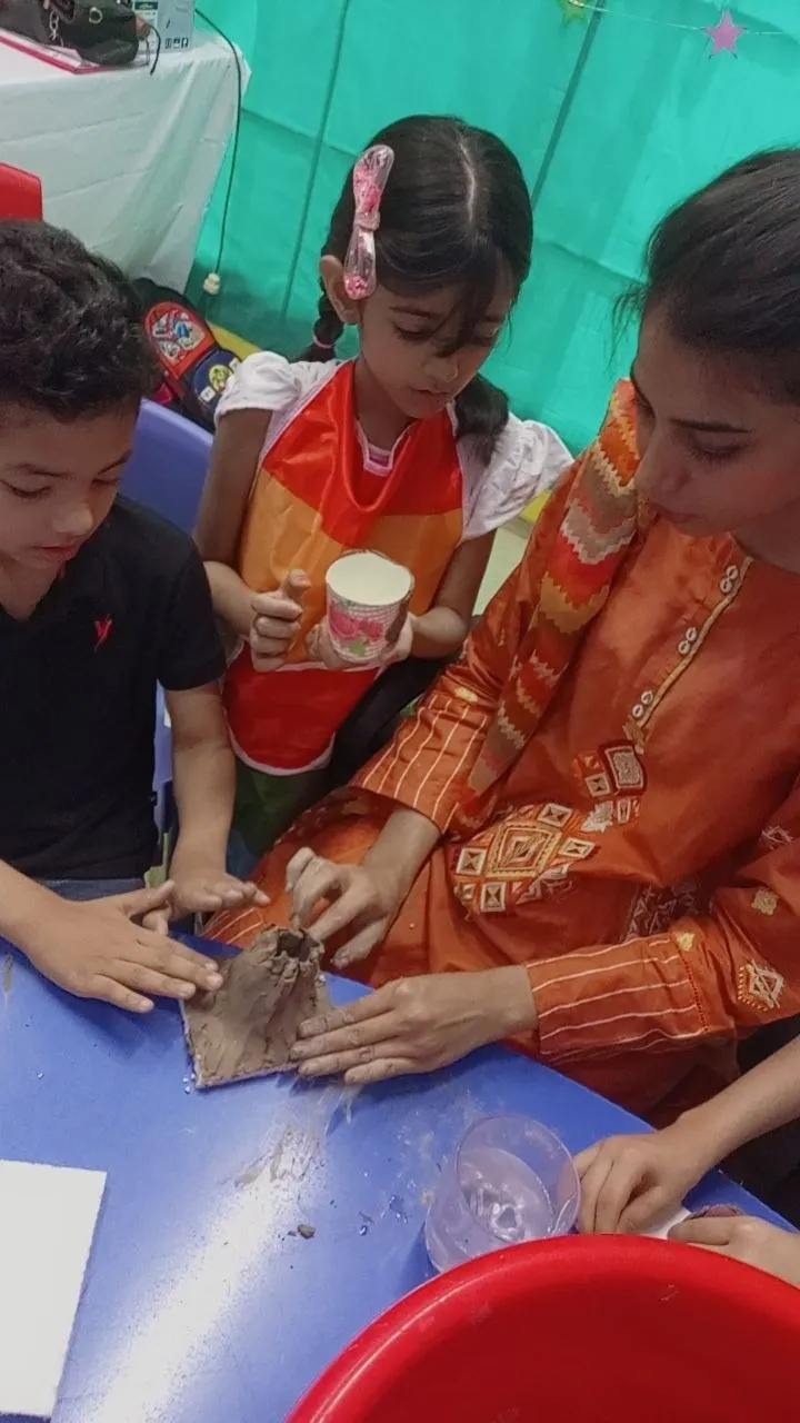 Students and a teacher making a model volcano in a science activity